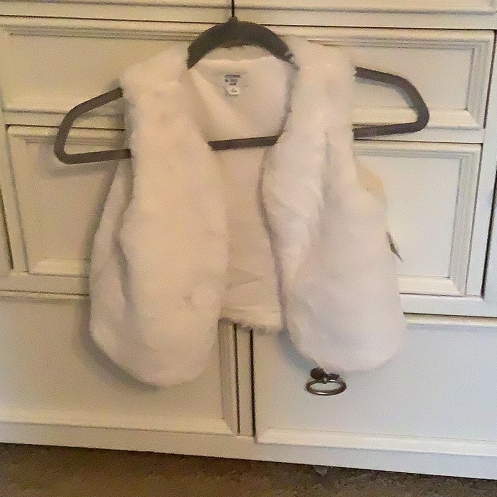I’m selling a white fluffy vest from belk, very cute for your kids or something.
